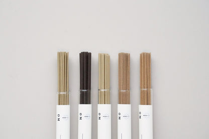 OM incense sticks in elegant tubes arranged on white background – ambergris and floral blend