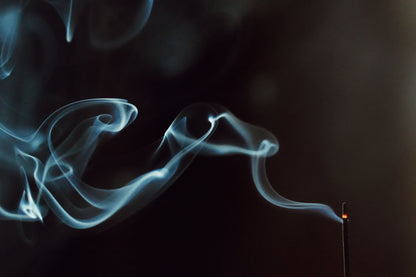 Incense smoke curling in darkness – OM Floating Sea scent in ritual moment
