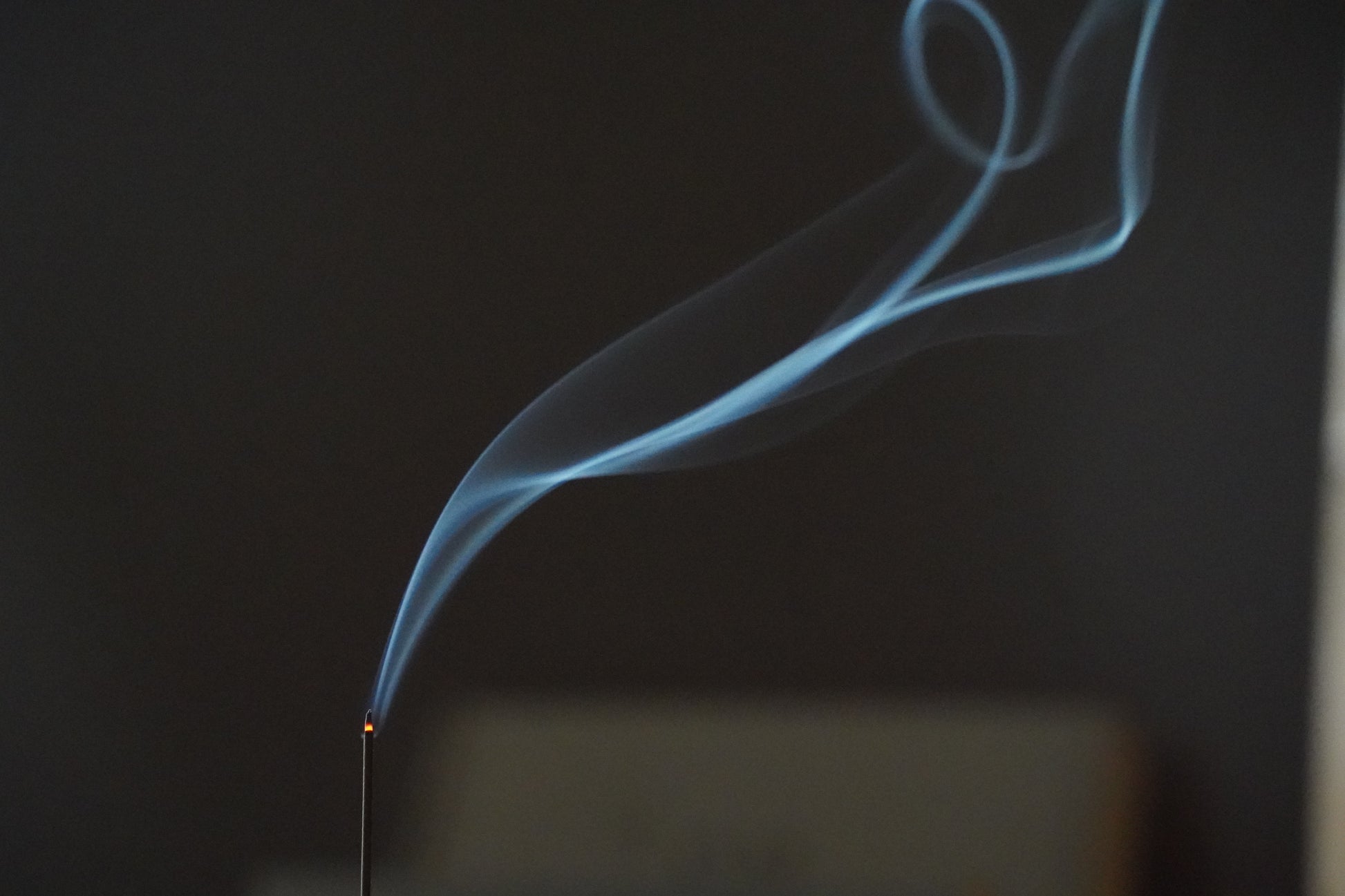 Fragrant incense smoke rising in the dark – OM ritual incense evoking Central Asian spices