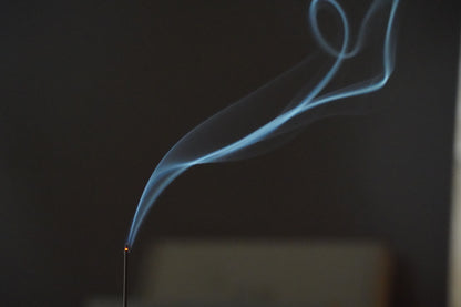 Fragrant incense smoke rising in the dark – OM ritual incense evoking Central Asian spices