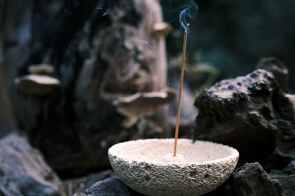 Close-up of incense smoke rising from cream white volcanic holder – OM sacred scent moment