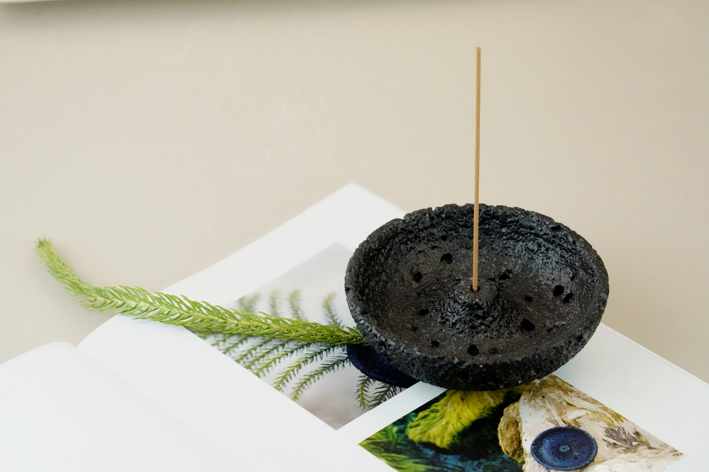 Close-up of black volcanic plaster incense holder with two incense sticks – OM scent pairing set