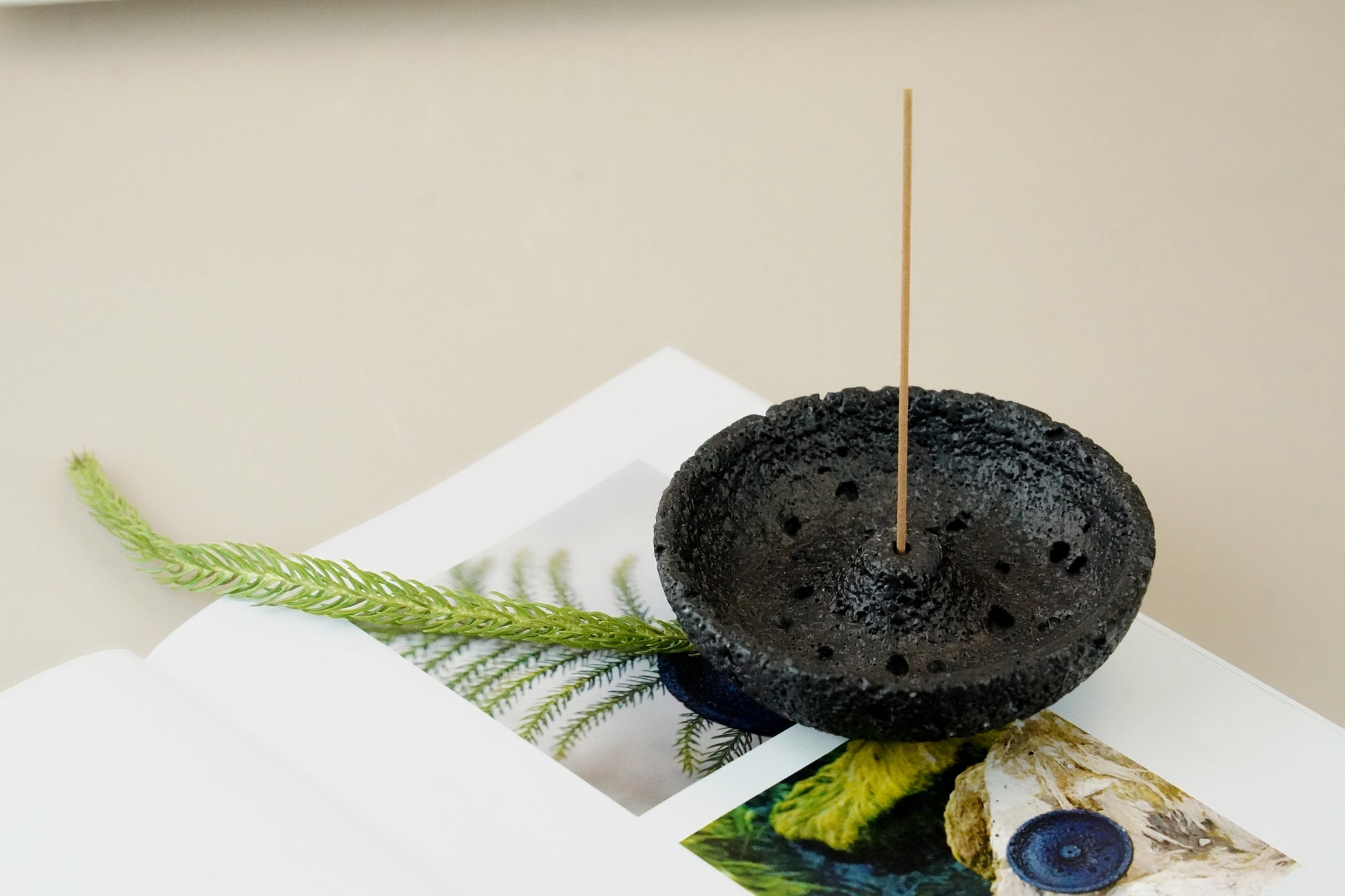 Close-up of black volcanic plaster incense holder with two incense sticks – OM scent pairing set
