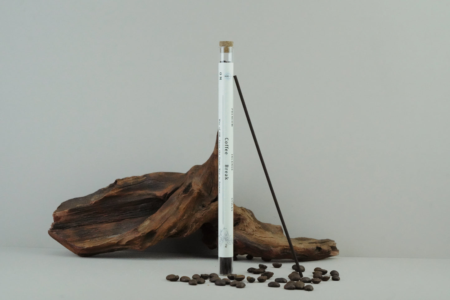 OM incense tube with coffee-themed design on wooden surface and natural linen – rustic warmth