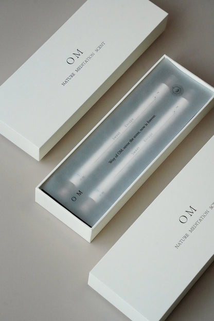 Close-up of incense packaging tube with OM branding – elegant floral and ambergris incense